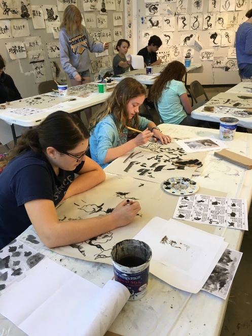Students at tables completing Sumi-e Ink Painting.